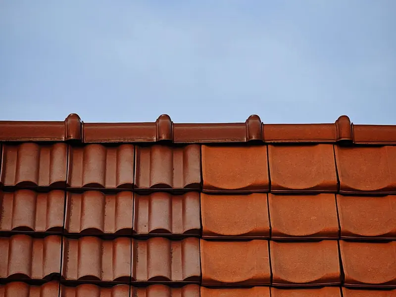 Close-up of terracotta barrel roof tiles against a blue sky